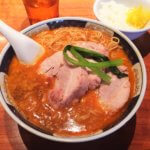 「支那麺 はしご 本店」の「太肉担々麺 だあろうだんだんめん 1,000円」とサービスライス、食べ放題のたくあん・龍馬漬け　一日以上煮たとってもやわらかいチャーシューがのった担々麺。サービスのご飯と酸味のきいたたくあんがラーメンのスープとよく合います♪